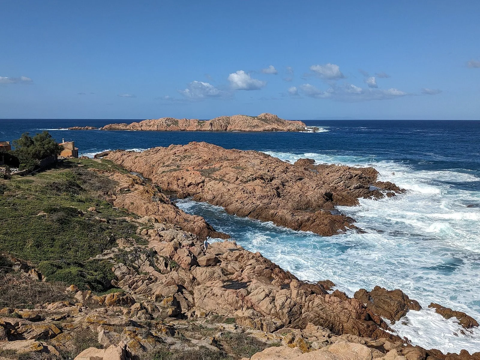 Le rocce rosse della costa di Isola Rossa con l'isolotto che d&agrave; il nome al borgo