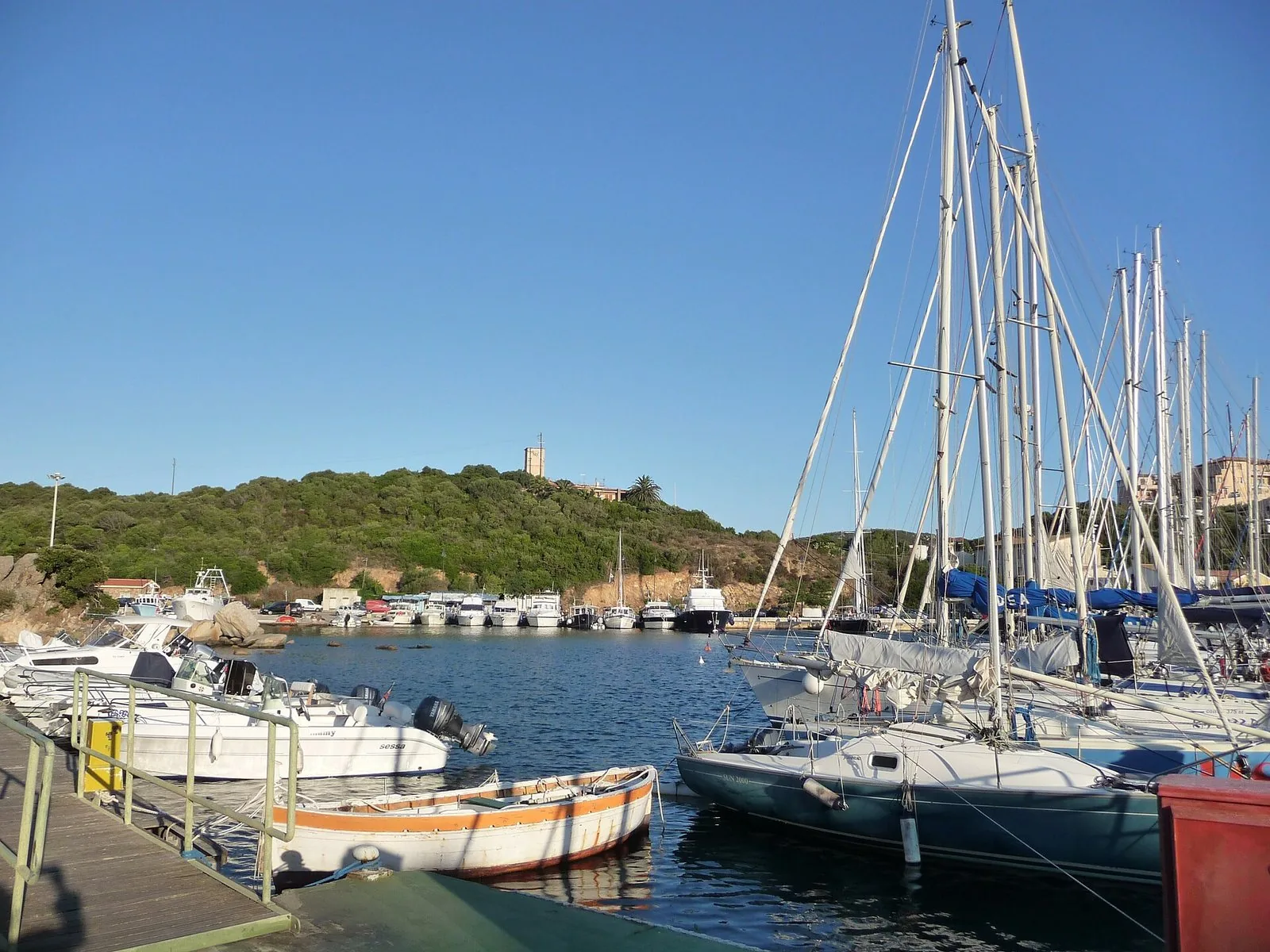 Il porto di Santa Teresa Gallura con le barche ormeggiate e la collina di macchia mediterranea